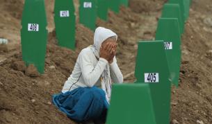 Жена плаче над гробове на жертви от клането в Сребреница