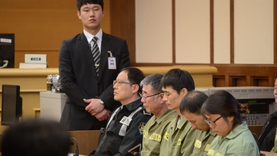 Капитан Ли Джон-сок (с прошарените коси) и други членове на екипажа пред съда
