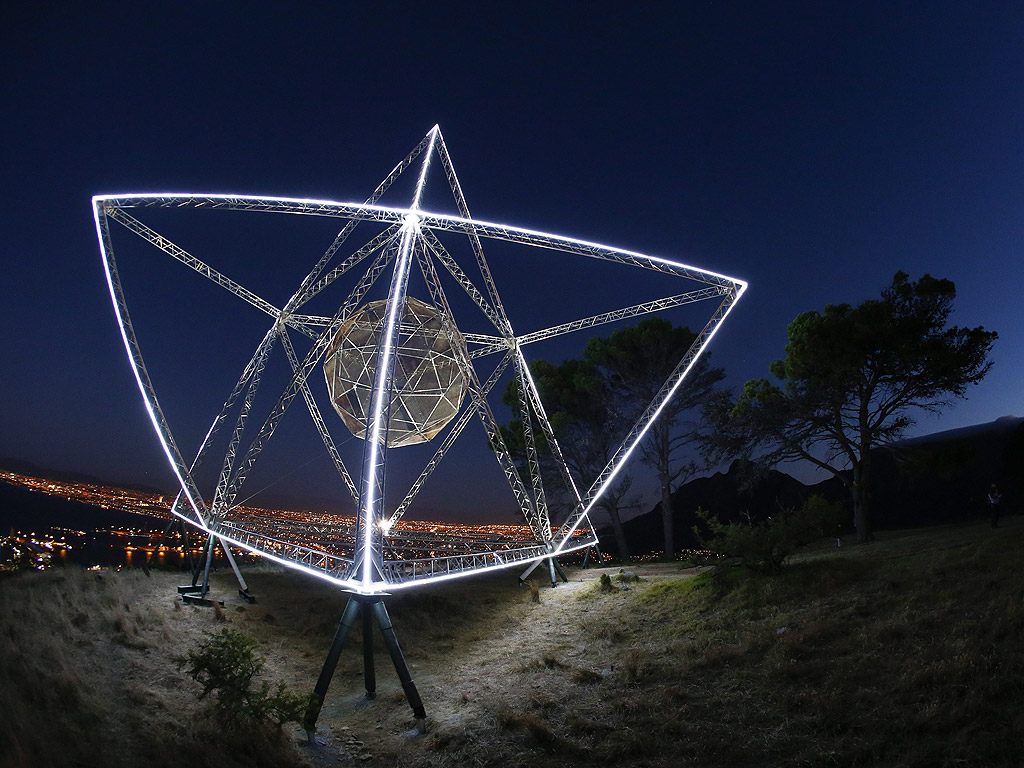 Инсталацията "Sunstar" от художника Кристофър Свифт над град Кейп Таун, Южна Африка. 24-метровата осмовърха звезда е изградена от стомана от оригинална ограда на остров Робен, където бившият президент Нелсън Мандела е бил в затвора 27 години.