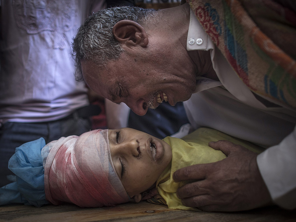 Баща оплаква загиналото си 10-годишно дете в Газа на 8 август. По данни на министерството на здравеопазването на Палестина при офанзивата на Израел в Ивицата Газа през лятото са загинали близо 1900 палестинци, а около 10 хиляди души са ранени