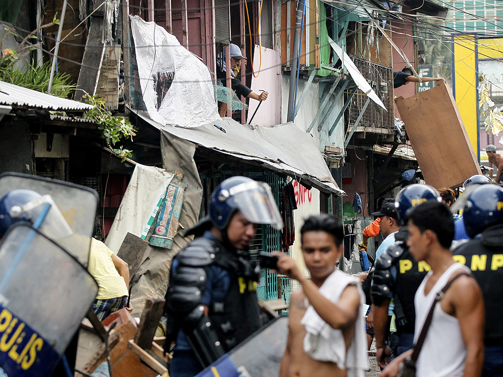 Съборяне на къщи в Куезон Сити, източно от Манила, Филипините. Според официалната местна власт, около 500 семейства са били изхвърлени от техните бараки, за да се даде път на изграждането на бизнес парк в района.