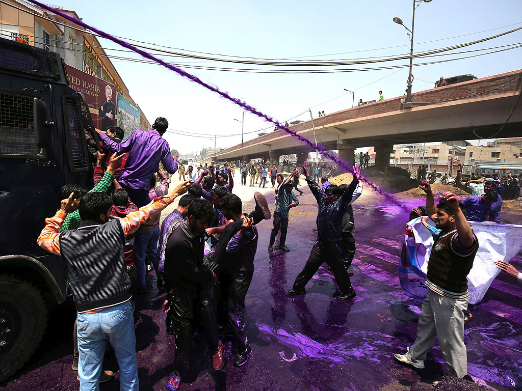 Държавни служители скандират лозунги, докато индийската полиция използва лилава струя вода, за да ги разпръсне, по време на протест в Шринагар, лятната столица на индийския щат Кашмир. Индийската полиция задържа десетки държавни служители, използвайки и водни оръдия, за да спрат тяхното протестно шествие