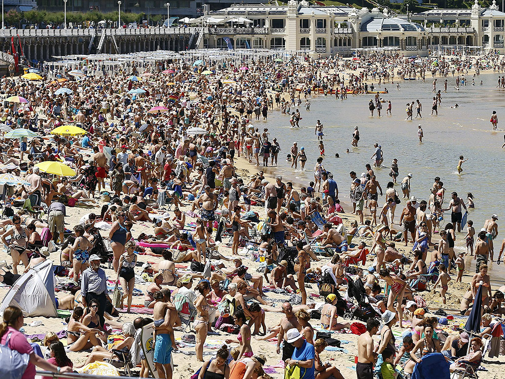 Хора се тълпят на плажа Ла Конча в Сан Себастиан, Страната на баските, Северна Испания. Температурите достигнаха 26 градуса по Целзий в Сан Себастиан