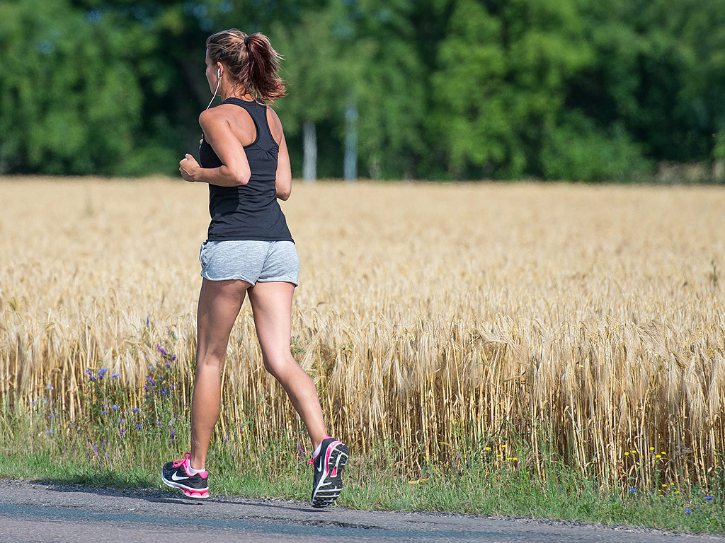 Жена тича до поле с ечемик в Waltersdorf, Германия. Горещо лятно време, с температури до над 35 градуса по Целзий, ще има в Централна Европа в следващите няколко дни