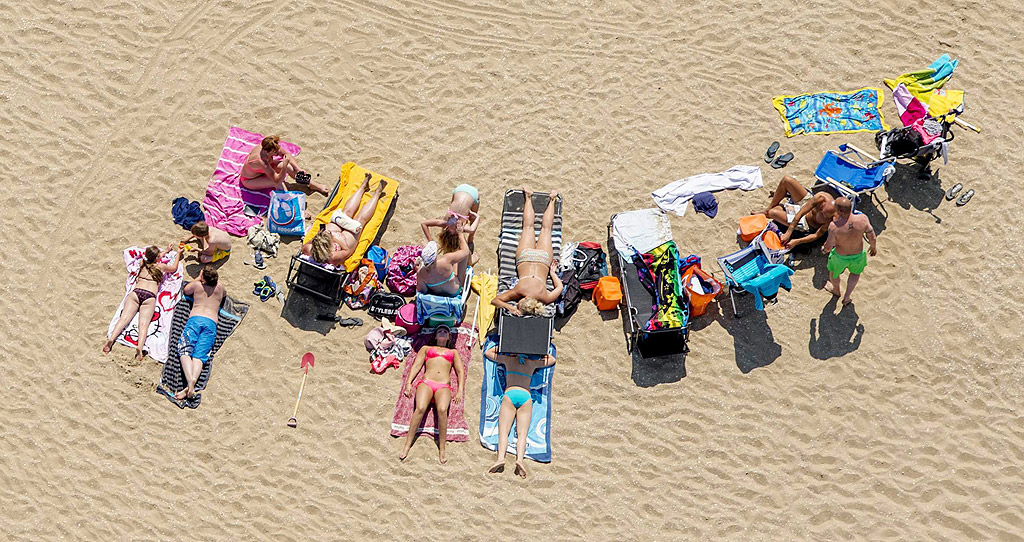Плажуващи на плажа в Схевенинген, Холандия се радват на топъл летен ден. Метеорологичния институт прогнозира слънчево и горещо време през следващите дни.