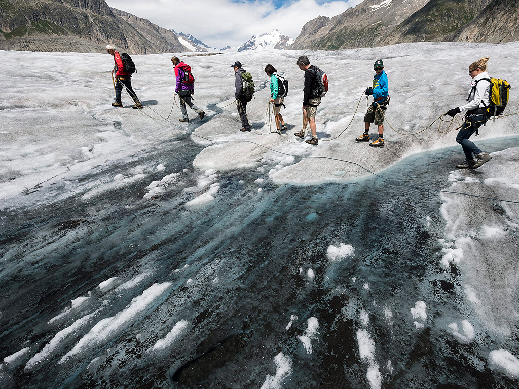 Туристи по време на обиколка с екскурзовод на ледника Алеч, във Фиш, Швейцария. Със своите 23км Ледника Алеч е най-дългият ледник в Европа и принадлежи към световното културно наследство на ЮНЕСКО.