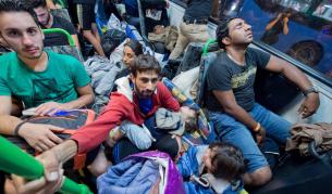 Бежанци пътуват в един от автобусите от Унгария към границата с Австрия