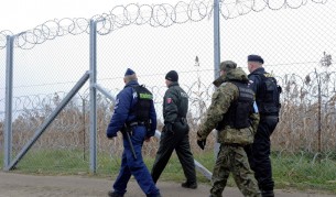 Унгарски и словашки полицаи заедно с полски граничар и чешки полицай патрулират край временната ограда на границата между Унгария и Сърбия