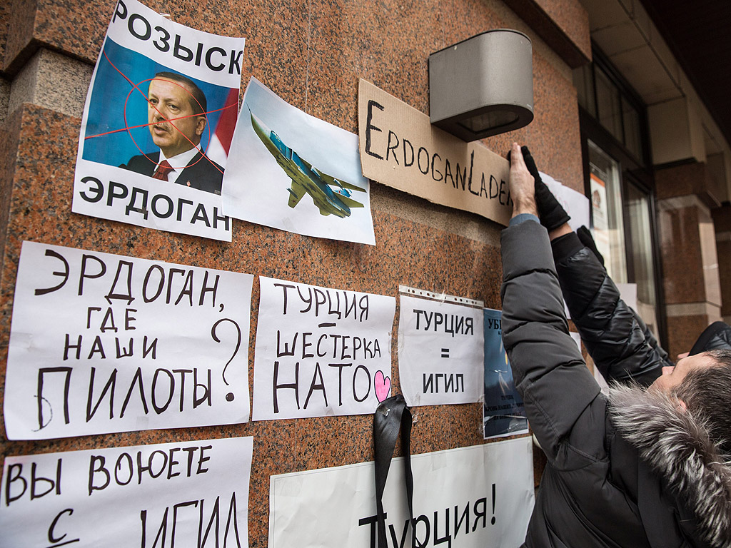 Руснаци държат плакати с текст "Ердоган е убиец" при протест пред турското посолство в Москва, Русия.
