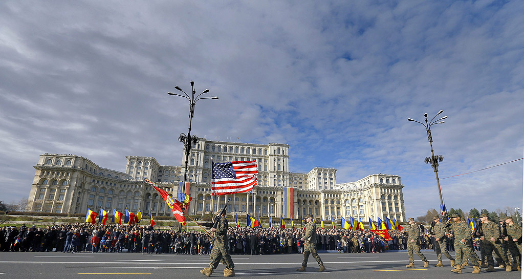 Американски морски пехотинци и войници от 3R-г батальон, 8-ми полк, маршируват пред сградата на парламента по време на военен парад за Националния празник на Румъния, в Букурещ. На 1-ви декември 1918 г. в Алба Юлия (Трансилвания) е свикан Национален съвет, където 600 депутати и 628 представители на културни и обществени организации гласуват обединението на областите Трансилвания, Кришана, Сатмар, Марамуреш и Банат. Над 2600 войници и специалисти, използващи 360 военни и технически средства участваха в парада, а хиляди хора се събраха за да гледат