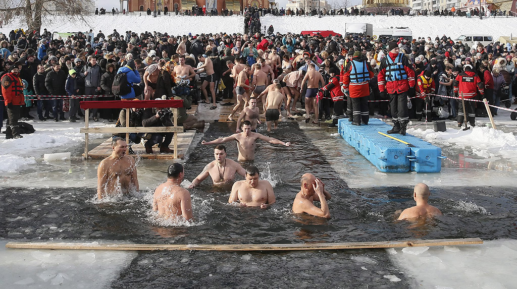 Православни вярващи се къпят в студена вода по време на Богоявленски тържества в Киев, Украйна. По време на Богоявление, някои хора вярват, че водите имат специални лечебни свойства и могат да бъдат използвани за лечение на различни заболявания, а много от тях правят ледени бани, като част от празника