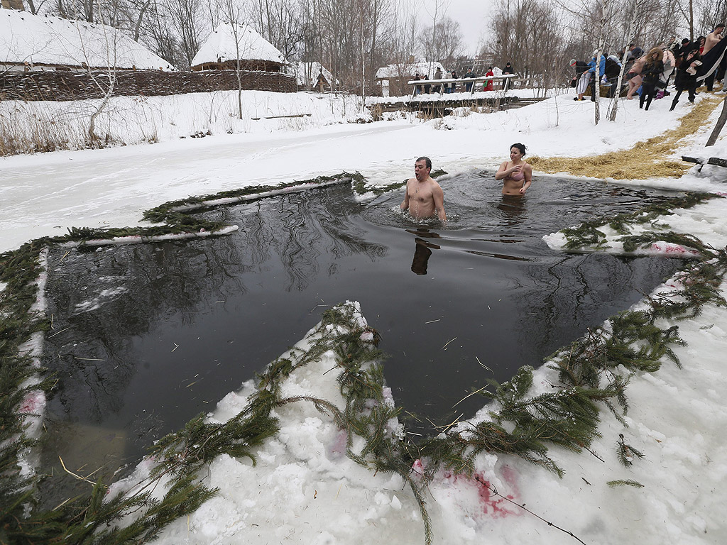 Православни вярващи се къпят в студена вода по време на Богоявленски тържества в Киев, Украйна. По време на Богоявление, някои хора вярват, че водите имат специални лечебни свойства и могат да бъдат използвани за лечение на различни заболявания, а много от тях правят ледени бани, като част от празника