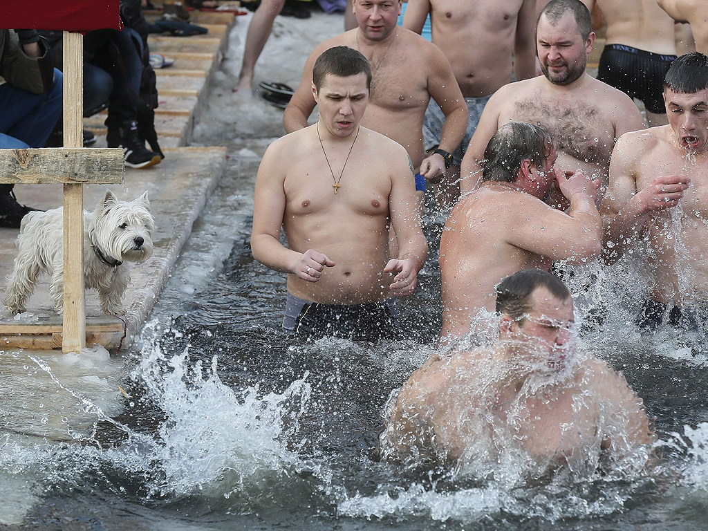 Православни вярващи се къпят в студена вода по време на Богоявленски тържества в Киев, Украйна. По време на Богоявление, някои хора вярват, че водите имат специални лечебни свойства и могат да бъдат използвани за лечение на различни заболявания, а много от тях правят ледени бани, като част от празника