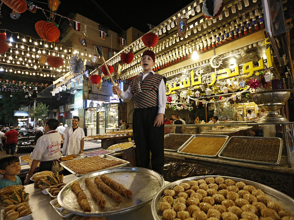 Сирийци продават сладкиши и храна на пазар по време на месец Рамадан в Дамаск, Сирия