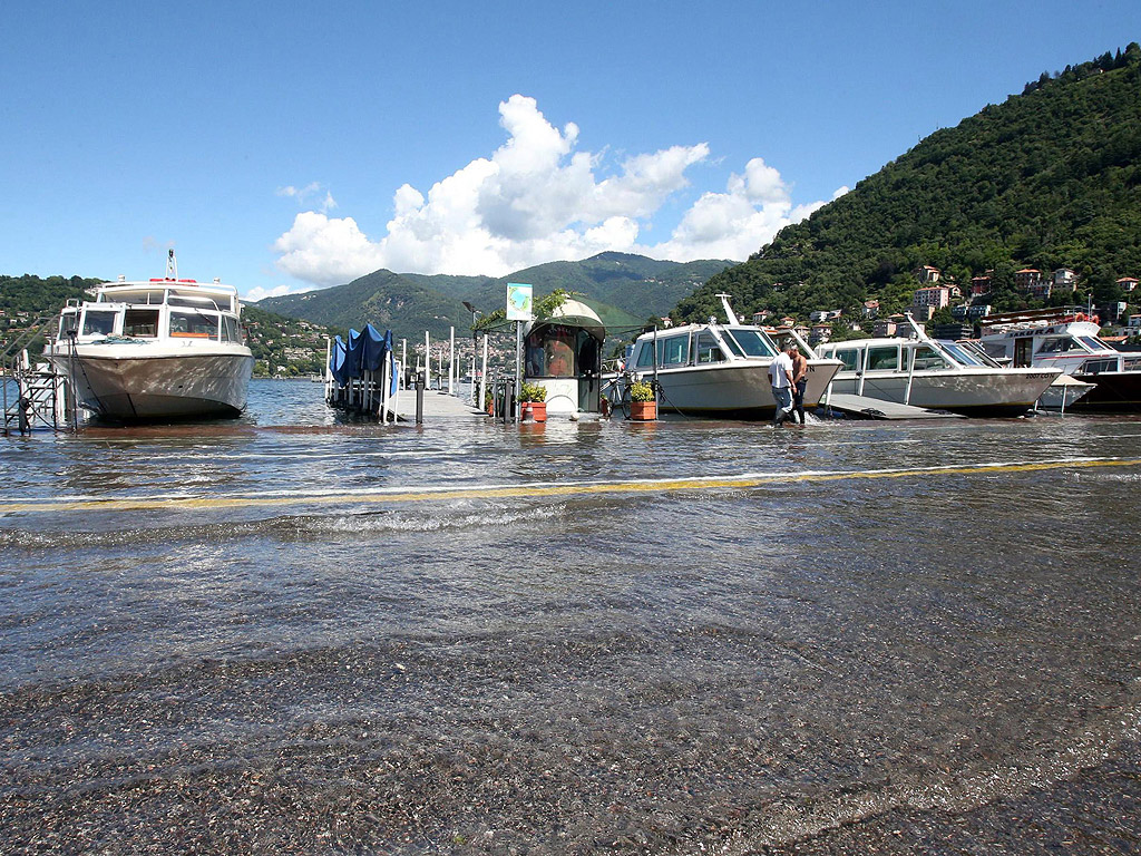 Лодки и яхти на пристана залят от придошлите води на езерото Комо в квартал Кавур в Комо, Италия