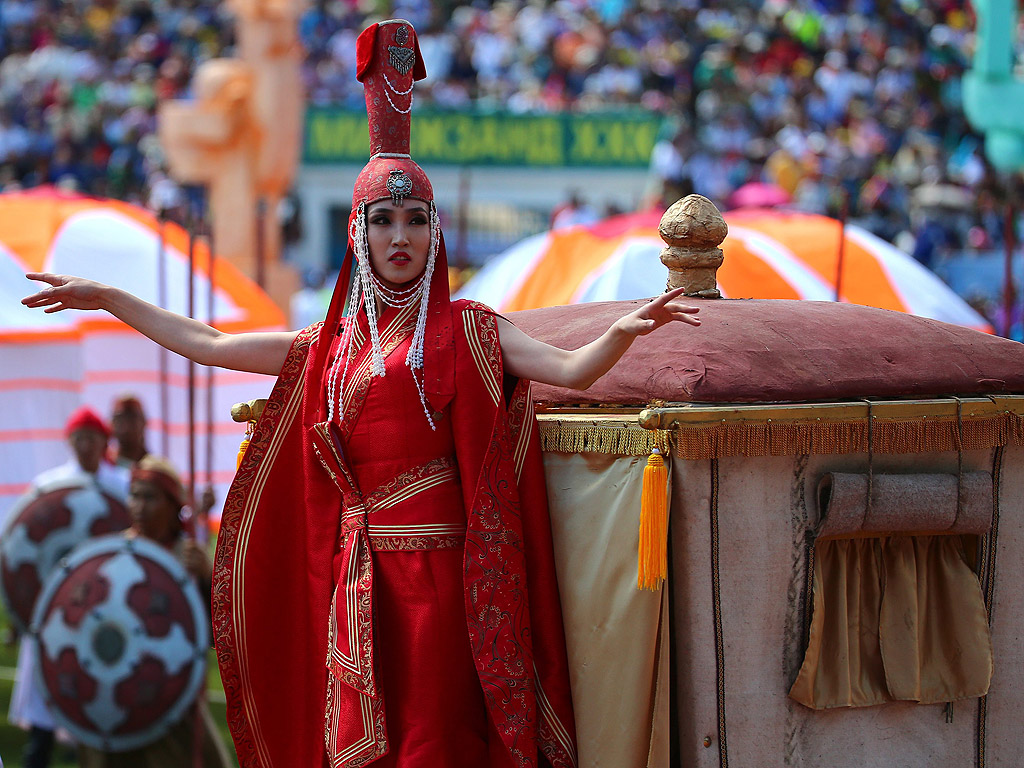 Монголци в традиционна носия по време на церемонията по откриването на фестивала Naadam в Улан Батор, Монголия. Ежегодния фестивал Naadam се провежда от 11 до 13 юли, е най-важният празник в годината и традиционен монголски конкурс за забавления и игри с конни надбягвания, борба и стрелба с лък - известен като "трите игри на мъжа"