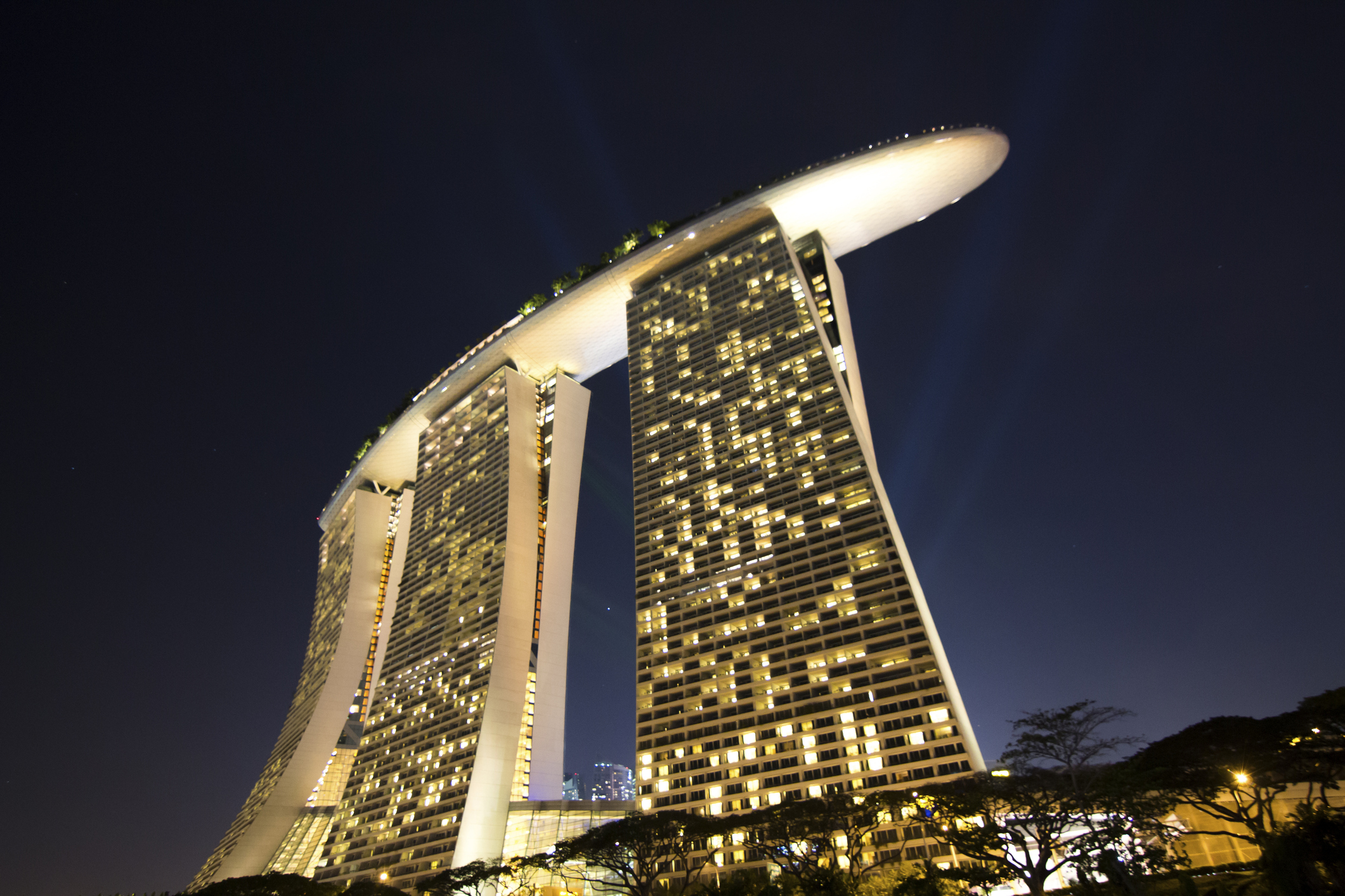 Марина Бей Сендс, Сингапур. Огромният комплекс се състои от 3 сгради на 55 етажа, които са свързани с общ покрив, на който се простира огромен басейн.<br />
Цена: 5,5 млрд. долара.