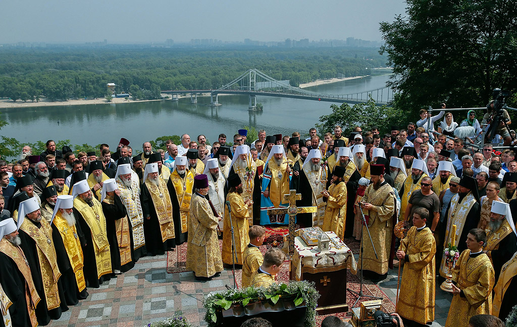 Украински православни свещеници, монаси, монахини и вярващи обграждат статуята на Свети Владимир по време на служба молитва в центъра на Киев, Украйна. В началото на юли, на две колони от православни вярващи, организирани от украинската православна църква на Московската патриаршия, от западна и източна Украйна направиха "Религиозно шествие за Мир" за да се срещнат в Киев на 27 юли. Православните вярващи бележат 1028-ма годишнина от християнизацията на Киевска Рус