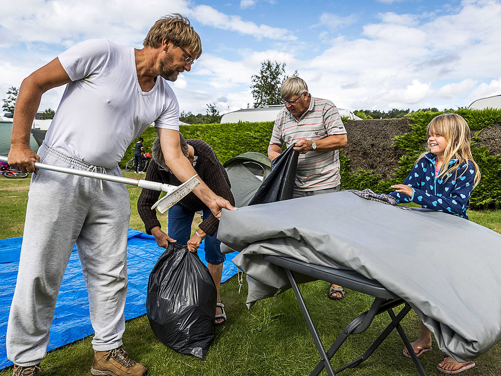 Посетители на къмпинг De Wulp в Нордвейк, Холандия, си стягат багажа. Поради лошото за сезона време в региона, много хора съкращават своята къмпинг почивка