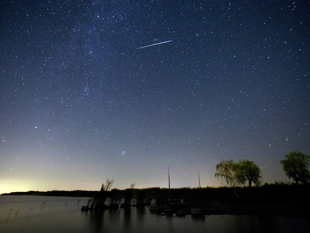 Метеор сред звездите в нощното небе югоизточно от Виена, Австрия. През първата половина на август е традиционно най-доброто време, за да се видят падащи метеори