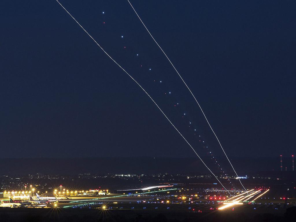 Снимка направена с дълга експозиция, показва следи от самолет, който се приземи на летището в Щутгарт, Германия