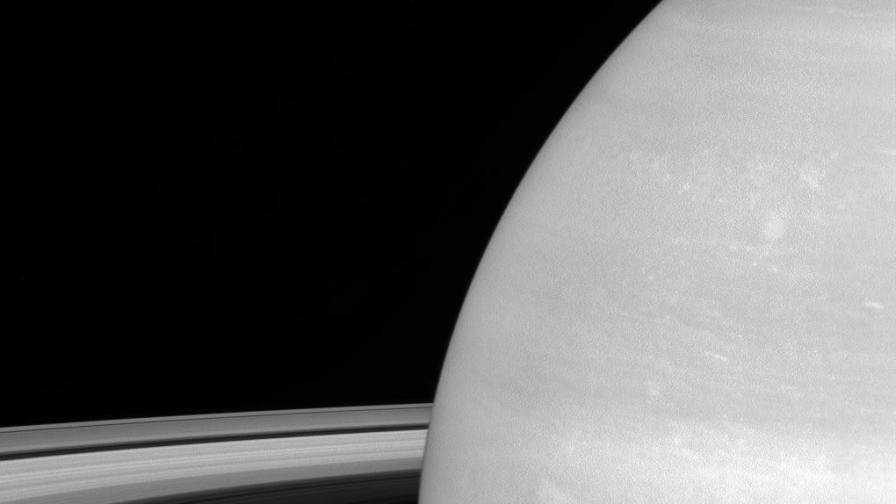 Луната Мимас на фона на Сатурн. Луната е с диаметър 396 км.
