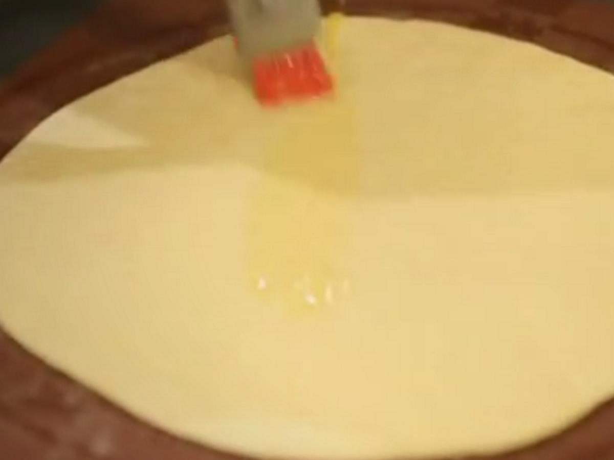 В тава, върху силиконов килим се поставя един кръг от тестото и се намазва с разтопено масло. Следва тесто, масло и така – докато се завърши с тесто.