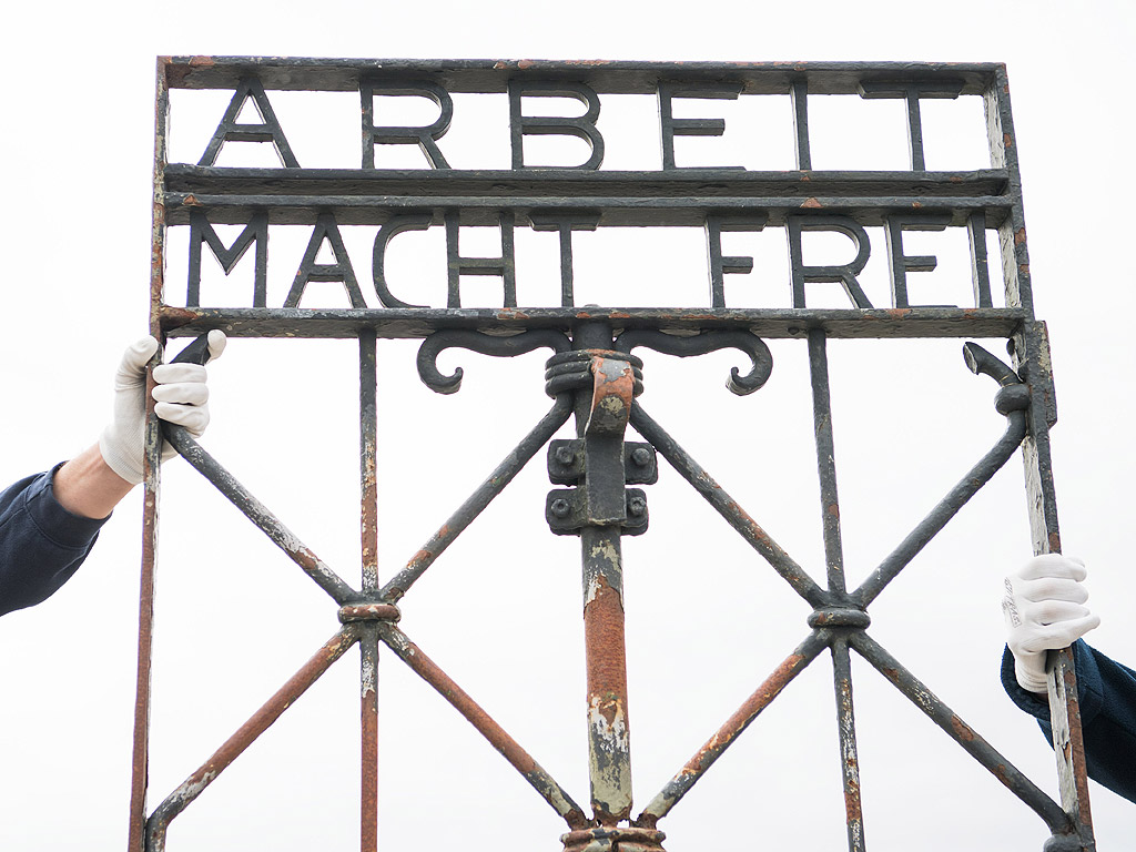Работници показват желязната порта с надписа "Arbeit Macht frei" (Работата ще те освободи) след завръщането й в лагера Дахау, Германия. Портата бе намерена от полицията в Норвегия, две години след като бе открадната на 2 ноември 2014. Вратата ще бъде изложена на показ в музея, а на нейно място има готова реплика