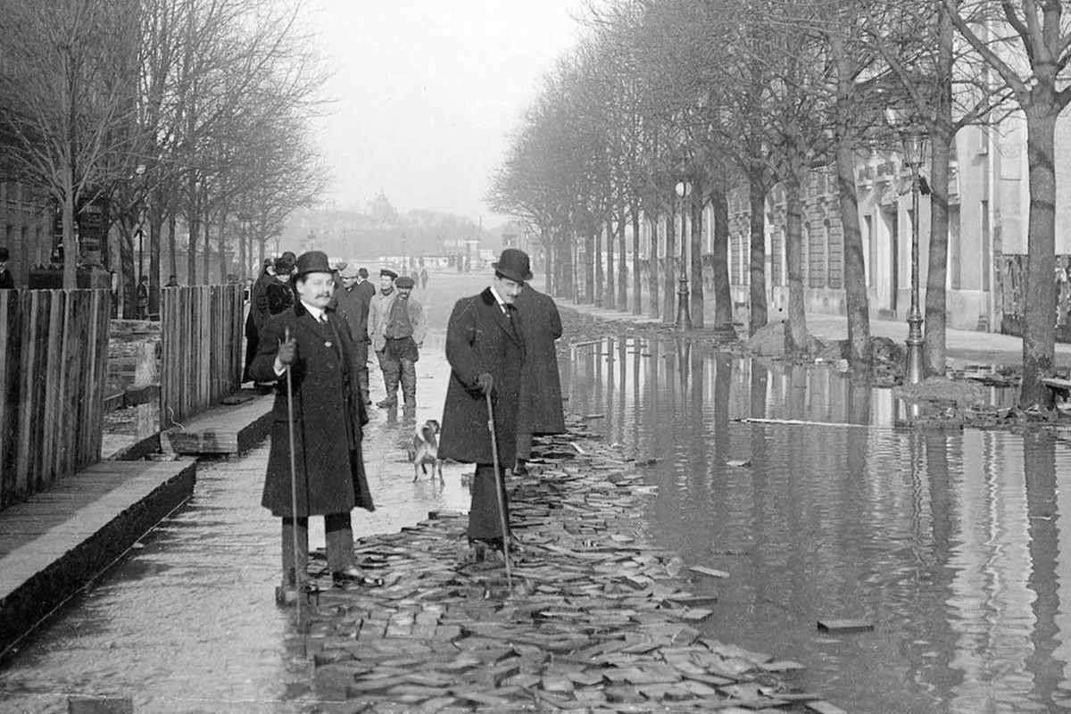 В края на януари 1910 г. след месеци на обилни валежи във Франция, в Париж река Сена пълни канализационните канали, тунелите на метрото, проправя си път до мазетата на хората и пропива напълно почвата.
За разлика от близките градчета, в които буйната река излиза от коритото си и залива всичко заобикалящо я, в Париж тя сякаш извира от самия град, за да го наводни.
За 10 дни водата достига до най-високото си ниво, а на 35-ия изчезва напълно. За щастие наводнението не отнема нито един живот. За сметка на това нанася щети на стойност над 400 млн. франка, равняващи се днес на 1.5 млрд.