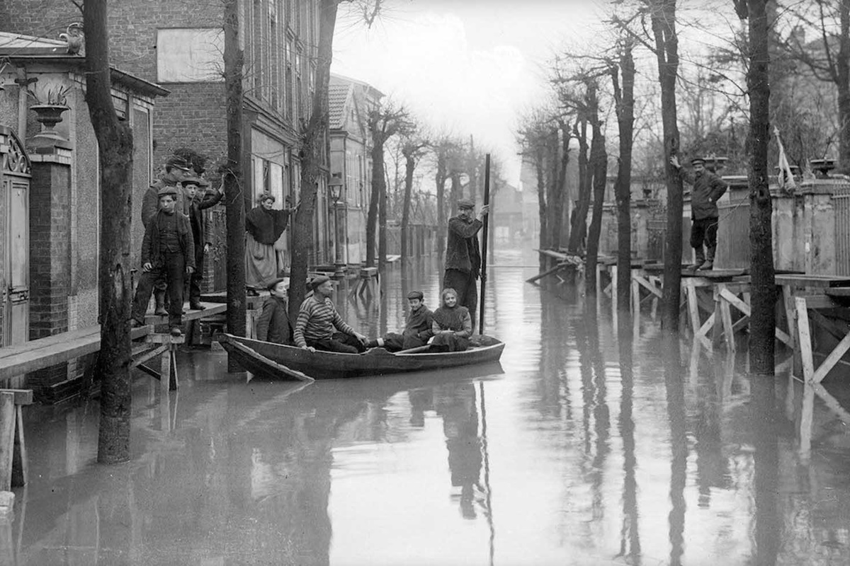 В края на януари 1910 г. след месеци на обилни валежи във Франция, в Париж река Сена пълни канализационните канали, тунелите на метрото, проправя си път до мазетата на хората и пропива напълно почвата.
За разлика от близките градчета, в които буйната река излиза от коритото си и залива всичко заобикалящо я, в Париж тя сякаш извира от самия град, за да го наводни.
За 10 дни водата достига до най-високото си ниво, а на 35-ия изчезва напълно. За щастие наводнението не отнема нито един живот. За сметка на това нанася щети на стойност над 400 млн. франка, равняващи се днес на 1.5 млрд.