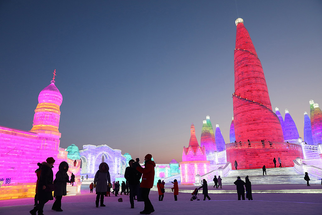 Хора разглеждат ледените скулптури, осветени от цветни светлини в град Харбин, Китай по време на 34-ия Международен фестивал на леда и снега. Около 180 000 кубически метра лед и 150 000 куб. метра сняг са използвани за изграждането на 800 000 квадратни метра скулптури за фестивалът, който ще продължи три месеца
