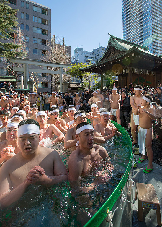 Мъже се молят и къпят в леденостудена вода по време на церемония в светилището Teppozu Inari в Токио, Япония. Стотици участват в тази церемония за пречистване на тялото и душата чрез издръжливост и на лед.