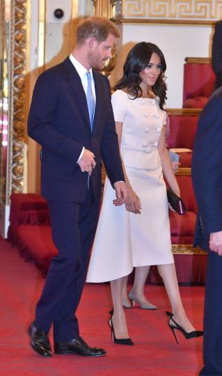 <p>След като принц Хари прекара малко време сам в Африка без съпругата си Меган Маркъл, херцозите на Уелс отново са заедно и дори присъстваха на официално събитие - в чест на кралица Елизабет II. Британският монарх бе домакин на ежегодната церемония в Бъкингамския дворец, наречена&nbsp;Young Leaders Awards. За мероприятието херцогинята на Уелс Меган Маркъл бе заложила на елегантна бледорозова визия, вдъхновена от модния бранд Прада. Изборът й на тоалет определено впечатли модните критици. Прическата й и гримът й също посрещнаха одобрение, тъй като бяха много естествени и ненатрапчиви.</p>