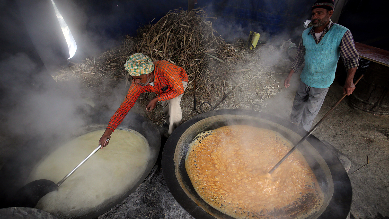 Индийски работници извличат сок от захарна тръстика, близо до село Вариам Нангал, на около 25 км от Амритсар, Индия