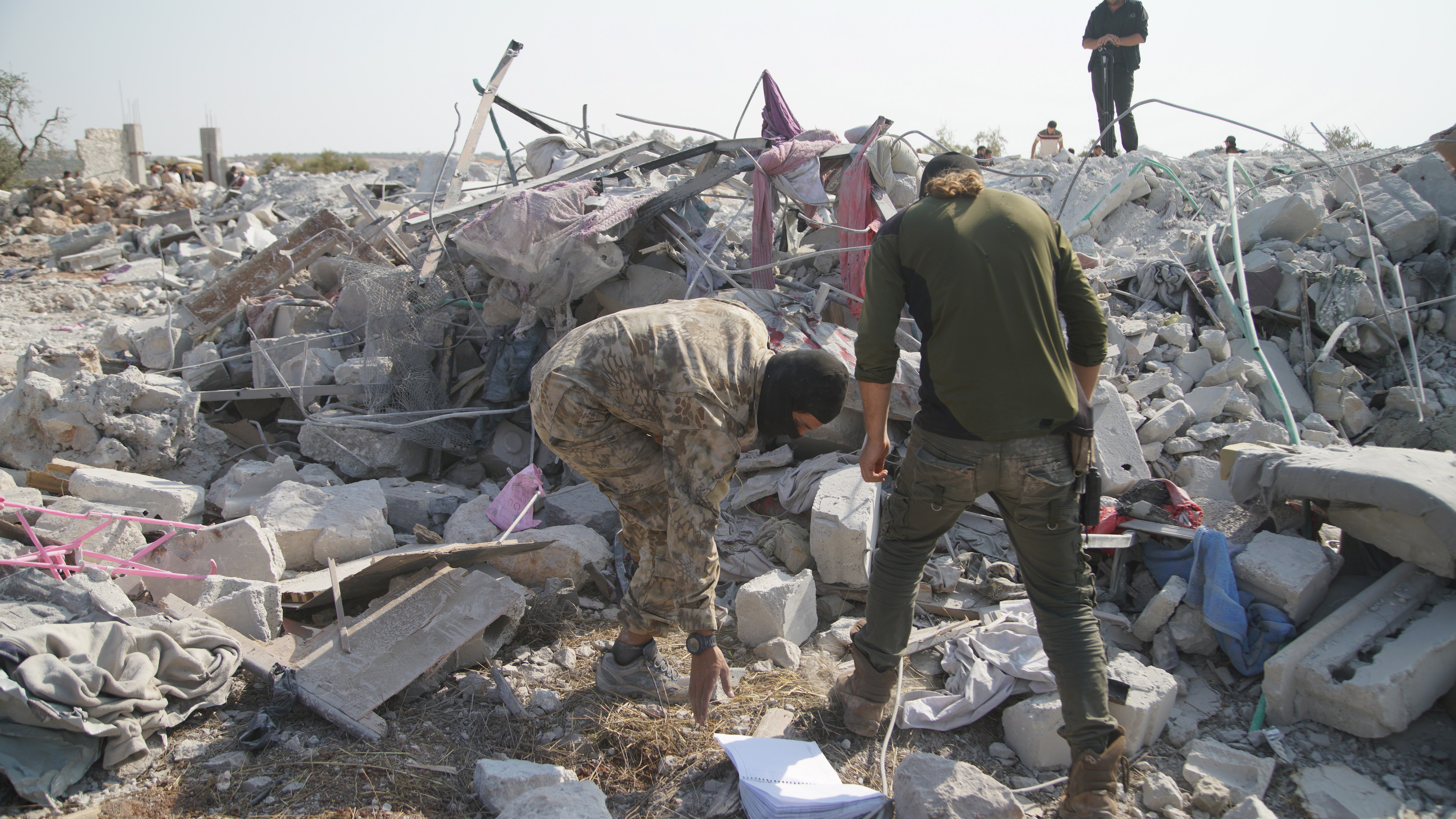 На снимките: Хора обикалят около развалините на разрушените сгради на мястото, което беше обстреляно в неделя. Според съобщения загинали са девет души, включително Абу Бейкър Ал Багдади - лидерът на "Ислямска държава". Кадрите са заснети близо до село Бариша, провинция Идлиб, Сирия, 27 октомври 2019 г. (издаден на 28 октомври 2019 г.)