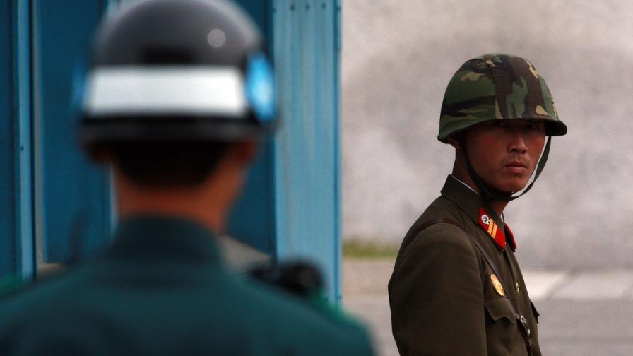 Севернокорейски и южнокорейски войник на границата между двете държави