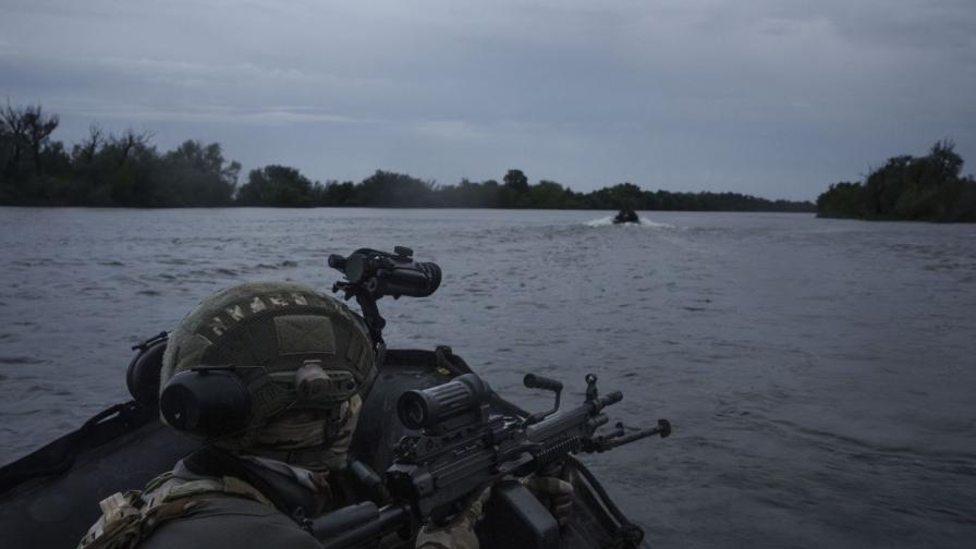 Украински войници се придвижват с лодки в река Днепър близо до Херсон.
