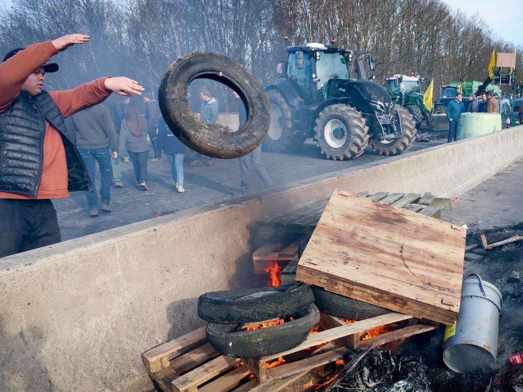Френските фермери започнаха да затварят основни магистрали около Париж, заплашвайки
