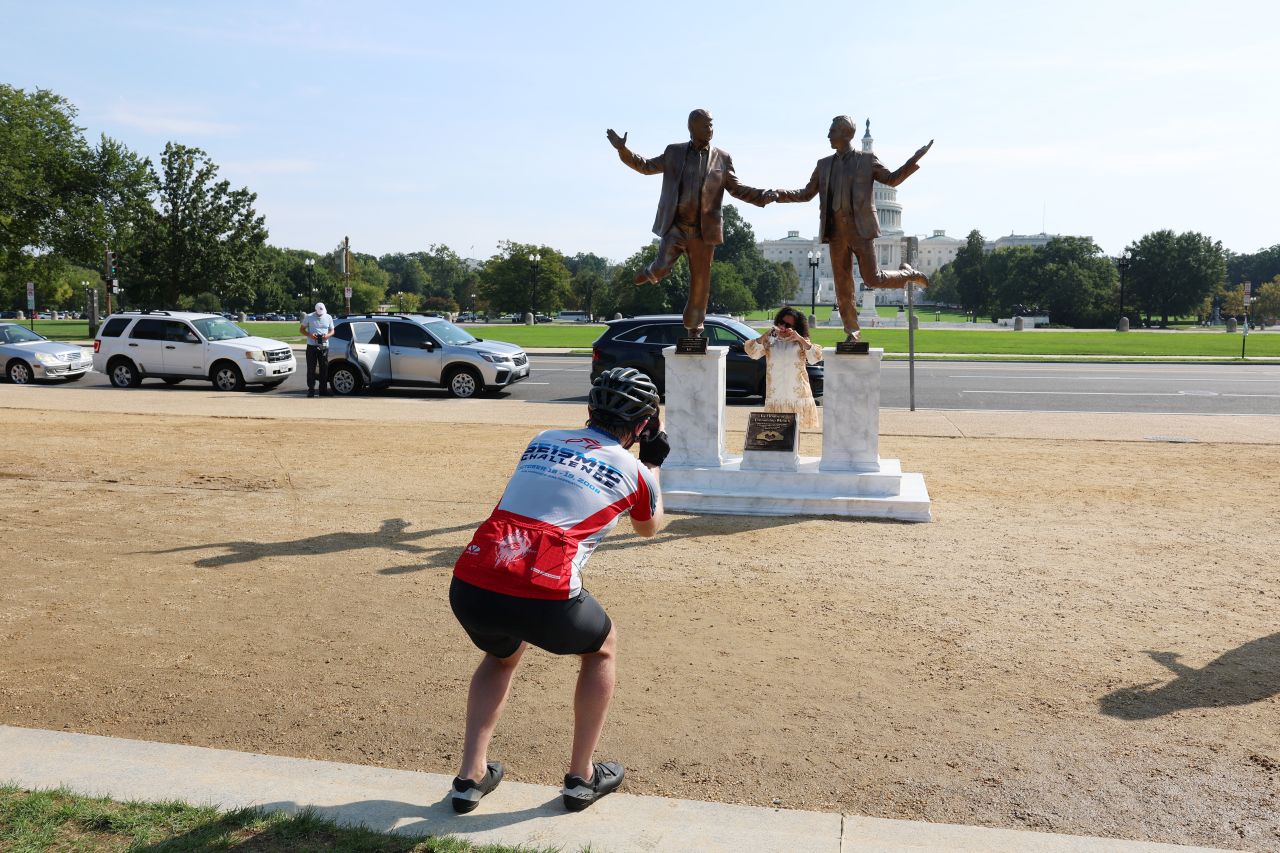 <p>Галерията представя новата бронзова статуя на National Mall, изобразяваща Доналд Тръмп и Джефри Епстийн в радостна поза. Инсталацията предизвика оживени реакции и дискусии, като акцентира върху миналата връзка между президента и осъдения трафикант.</p>