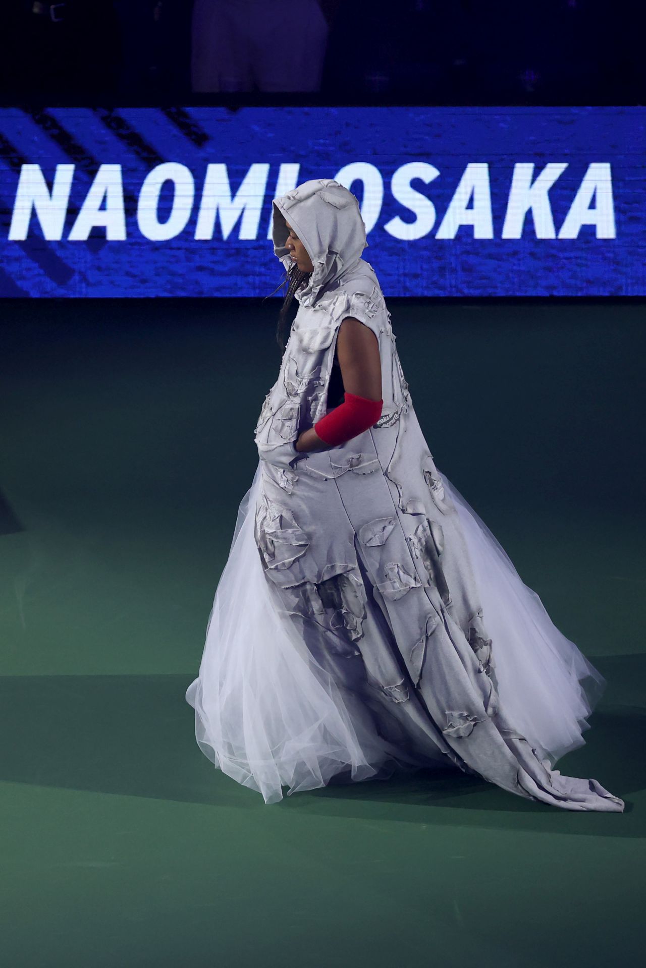 <p>Четирикратната шампионка от Големия шлем шокира феновете на US Open с роба от вестникарски заглавия и екип в стил Алън Айвърсън. Японката премина през труден мач срещу Захарова и обеща още модни изненади в следващия кръг.</p>
