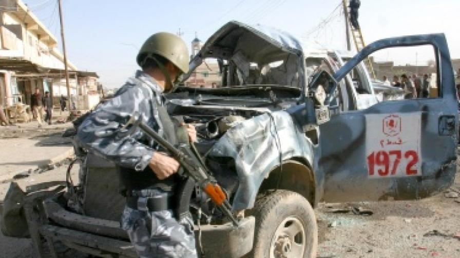 Иракски войник оглежда пострадала кола след атентат в Мосул