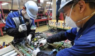 Работници в "Панасоник" разглобяват стари телевизори в еко отдела.