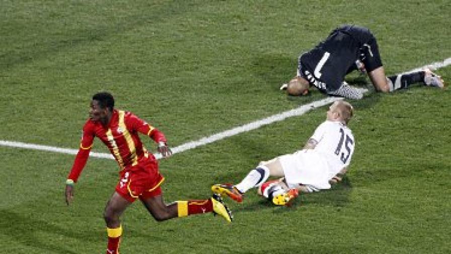 Асамоа Гиан ликува, след като отбеляза победния гол за Гана, докато американският защитник Джей Демерит и вратарят Тим Хауърд не могат да повярват на малшанса си