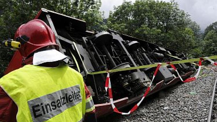Пожарникар от спасителните екипи пред преобърнатия вагон от влака