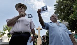 Възрастни румънци демонстрират със снимки на Чаушеску пред гроба на бившия комунистически лидер