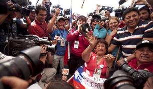 Маргарита Рохо, майката на един от затрупаните миньори (Дарио Деговиа), празнува изваждането на повърхността на сина й пред многобройните камери и фотоапарати на медии от цял свят