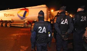 Полицията наблюдава как цистерна зарежда бензин от склад в Льо Ман, след като преди това разгони протестиращите, блокирали пътя до резевроярите