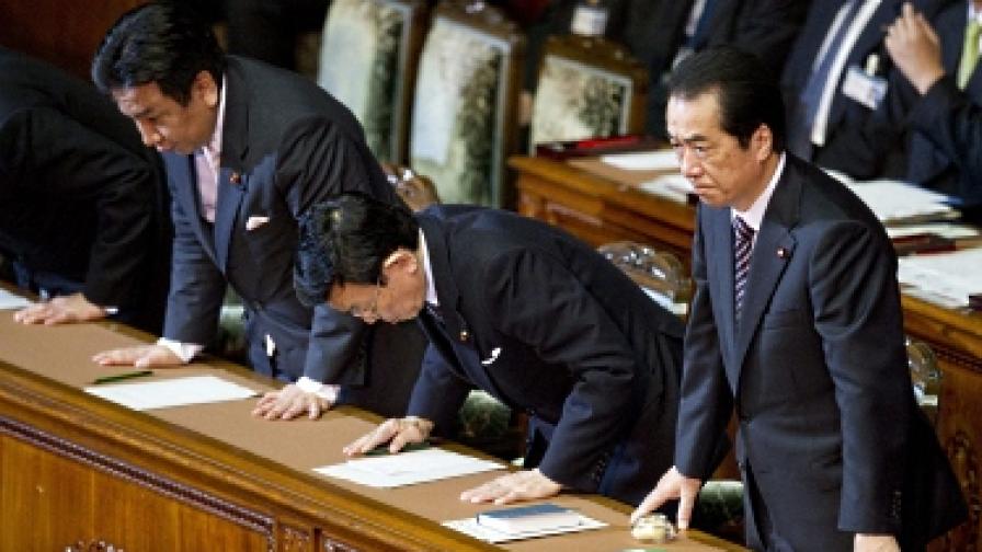 Премиерът Наото Кан и членове на кабинета му се покланят на залата, след като парламентът отхвърли вот на недоверие към правителството