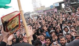 Афганистанци, работещи в "Баграм", носят обгорени екземпляри на свещената си книга