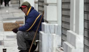 Просяк на улицата в Атина държи табела, на която пише "Моля ви, гладен съм"